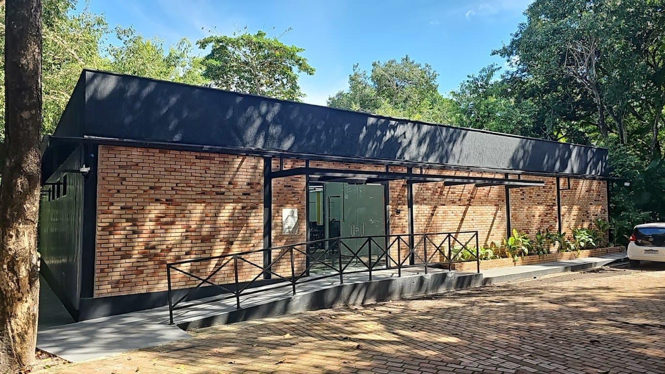 Fachada do laboratório NEXUS, prédio de tijolos cercado por árvores
